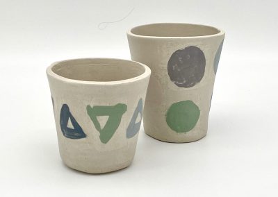 Das Bild zeigt Keramikbecher, die mit verschieden eingefärbten Engoben gestaltet wurden.